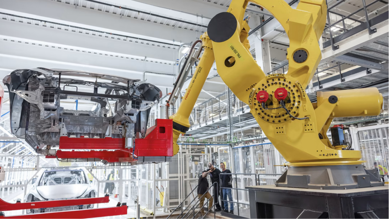 Robotic arm assembling a SUN Motors vehicle on the production line